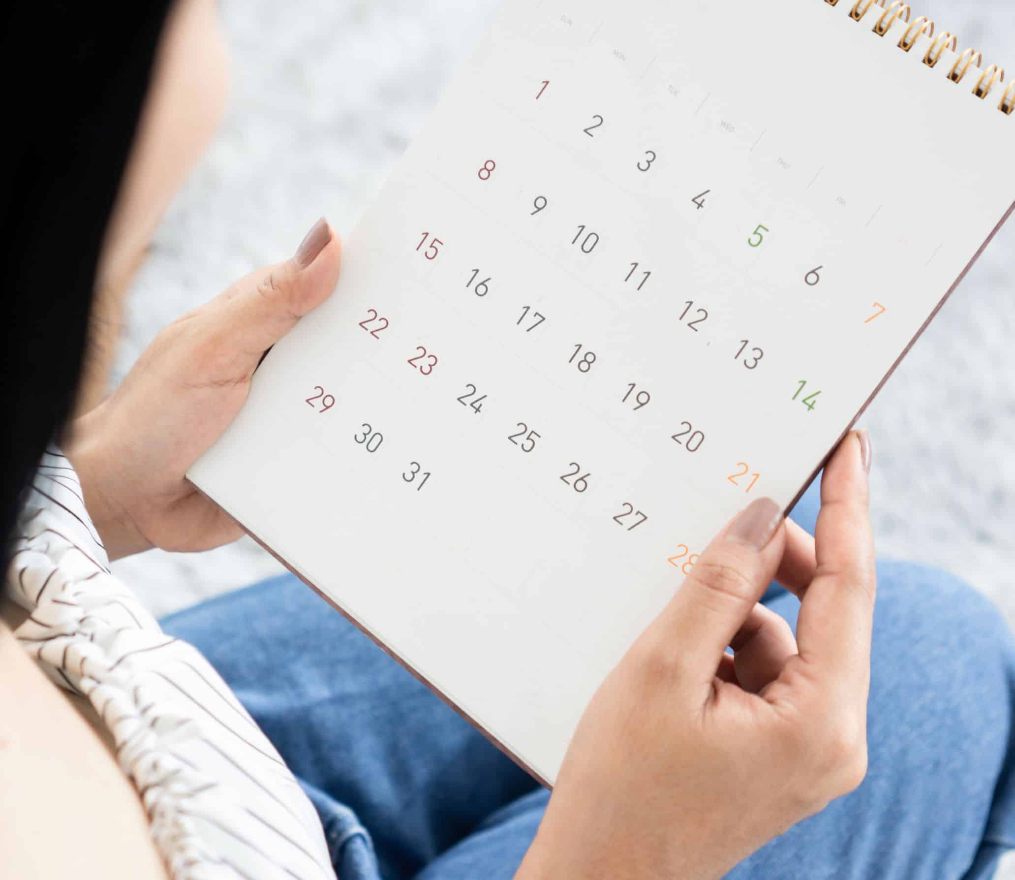 A woman looking at her calendar tracking her period.