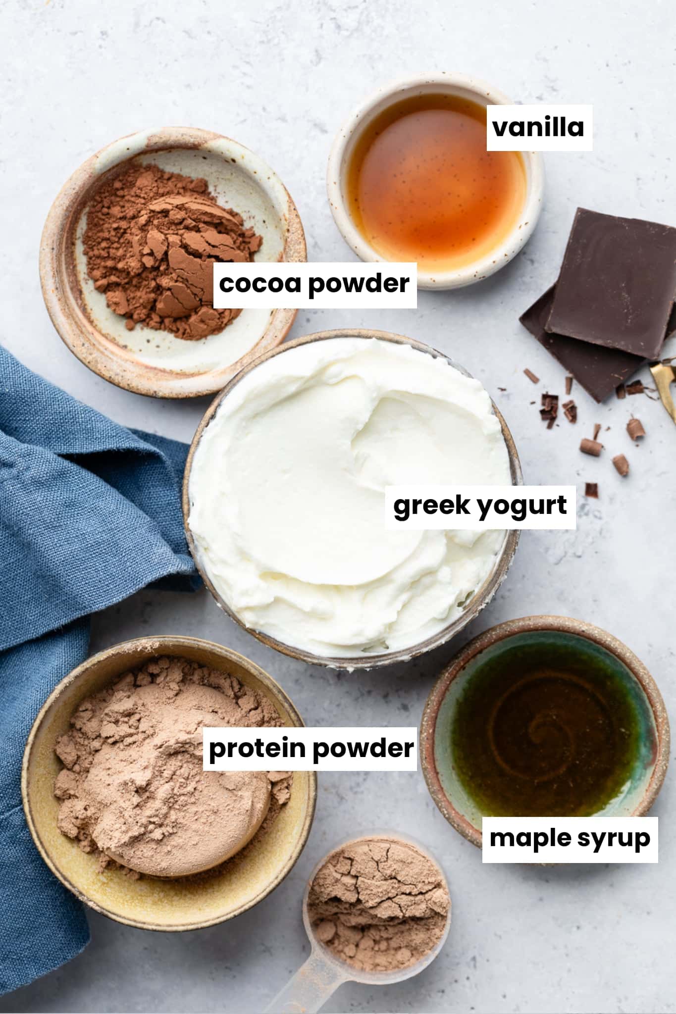 Ingredients in the recipe, including greek yogurt, protein powder, maple syrup, cocoa powder, and vanilla.