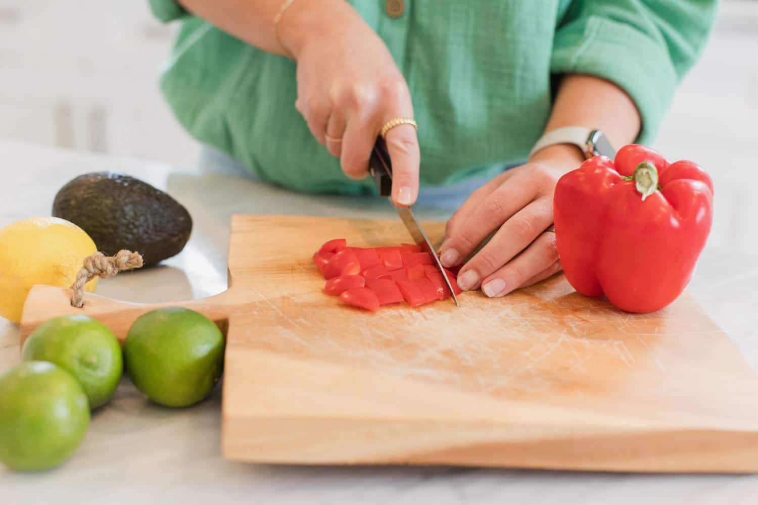 Cutting up fresh vegetables on a cutting board to make a healthy recipe.