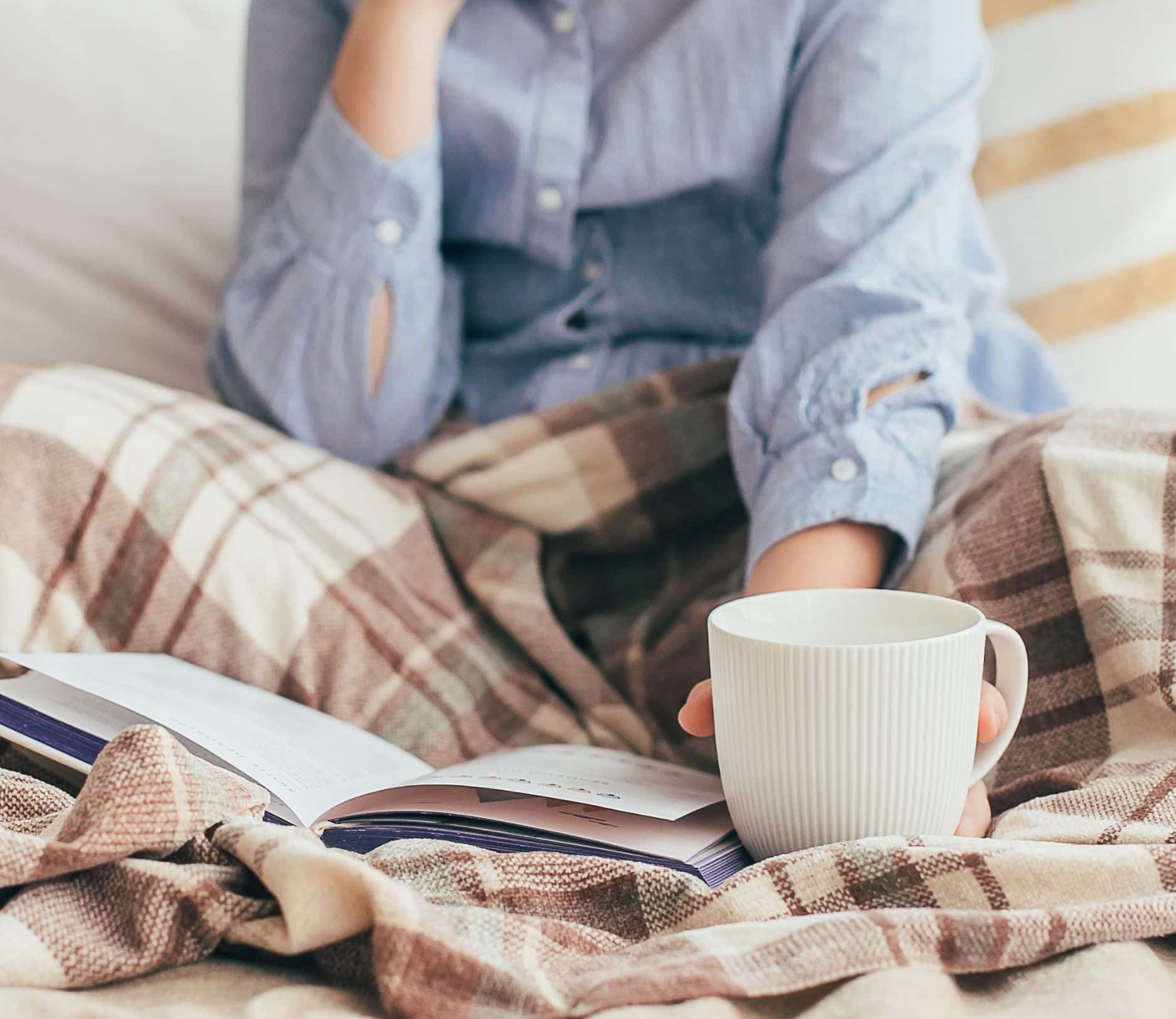 Woman resting trying to reduce stress and drink a mug of tea.