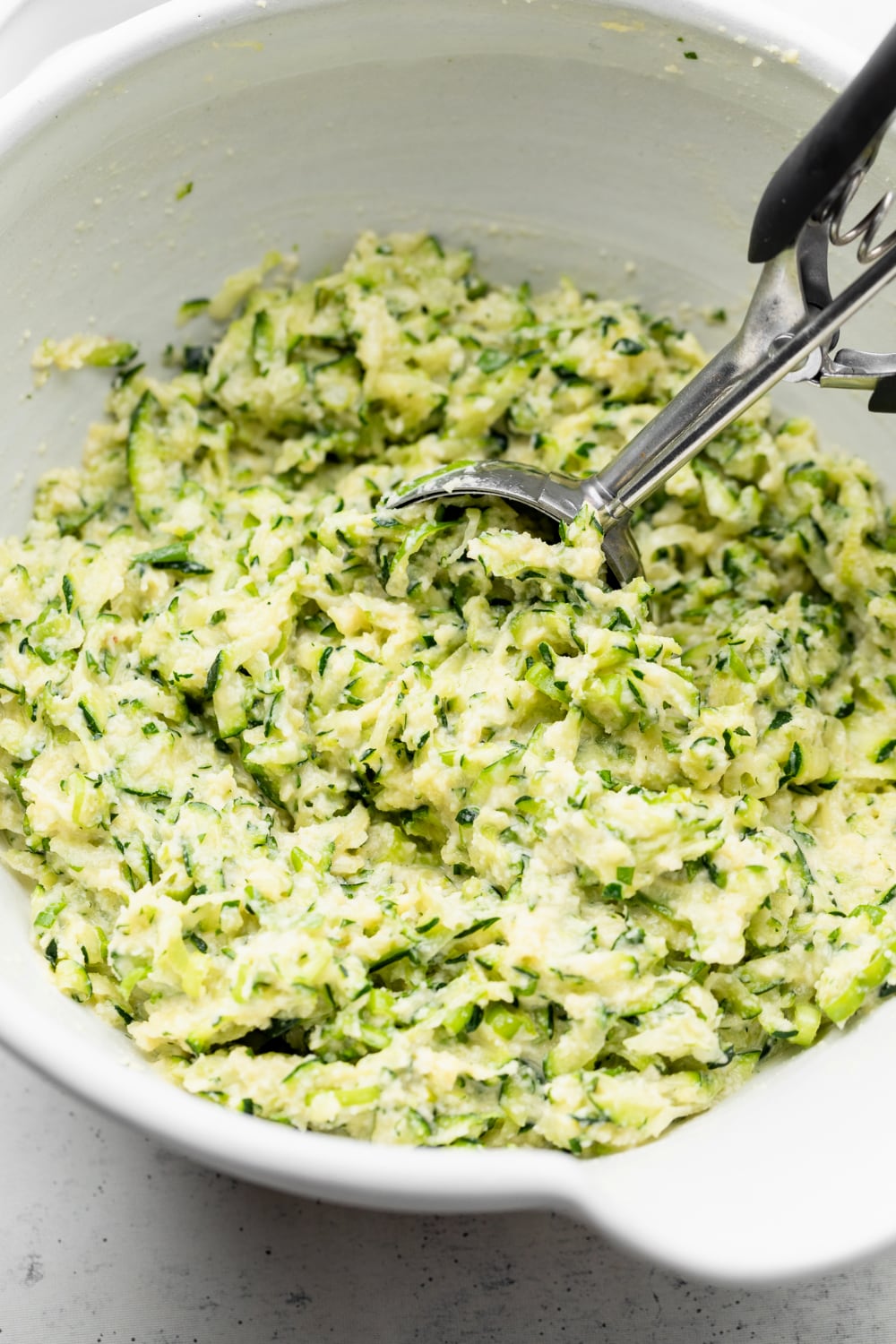 Batter for zucchini fritters in a bowl.