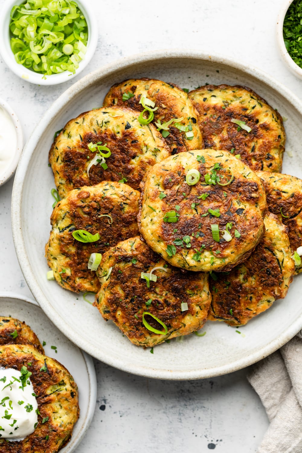 Fritters on a plate with chives on top.