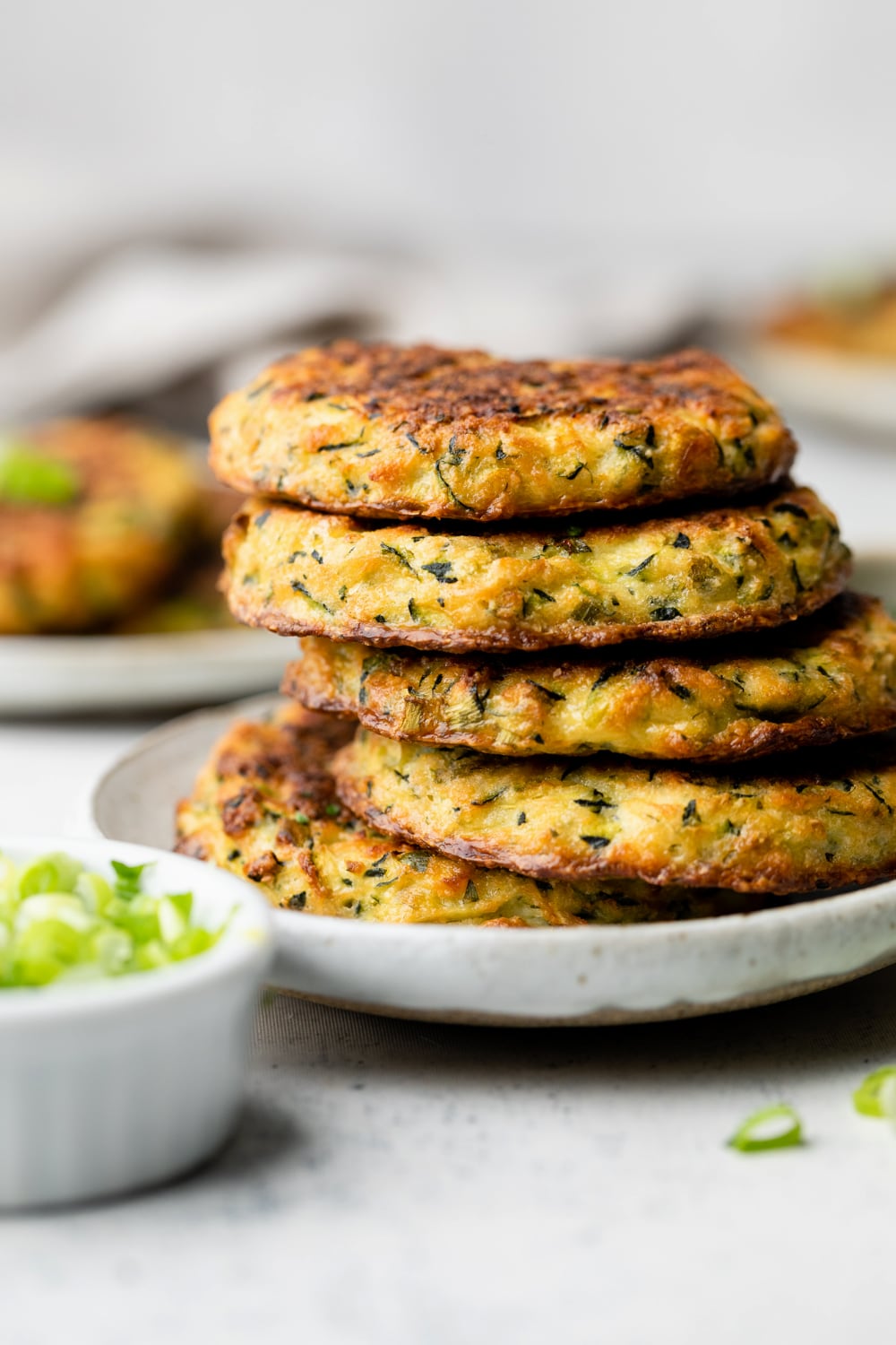 Stack of oven baked zucchini fritters on a plate.