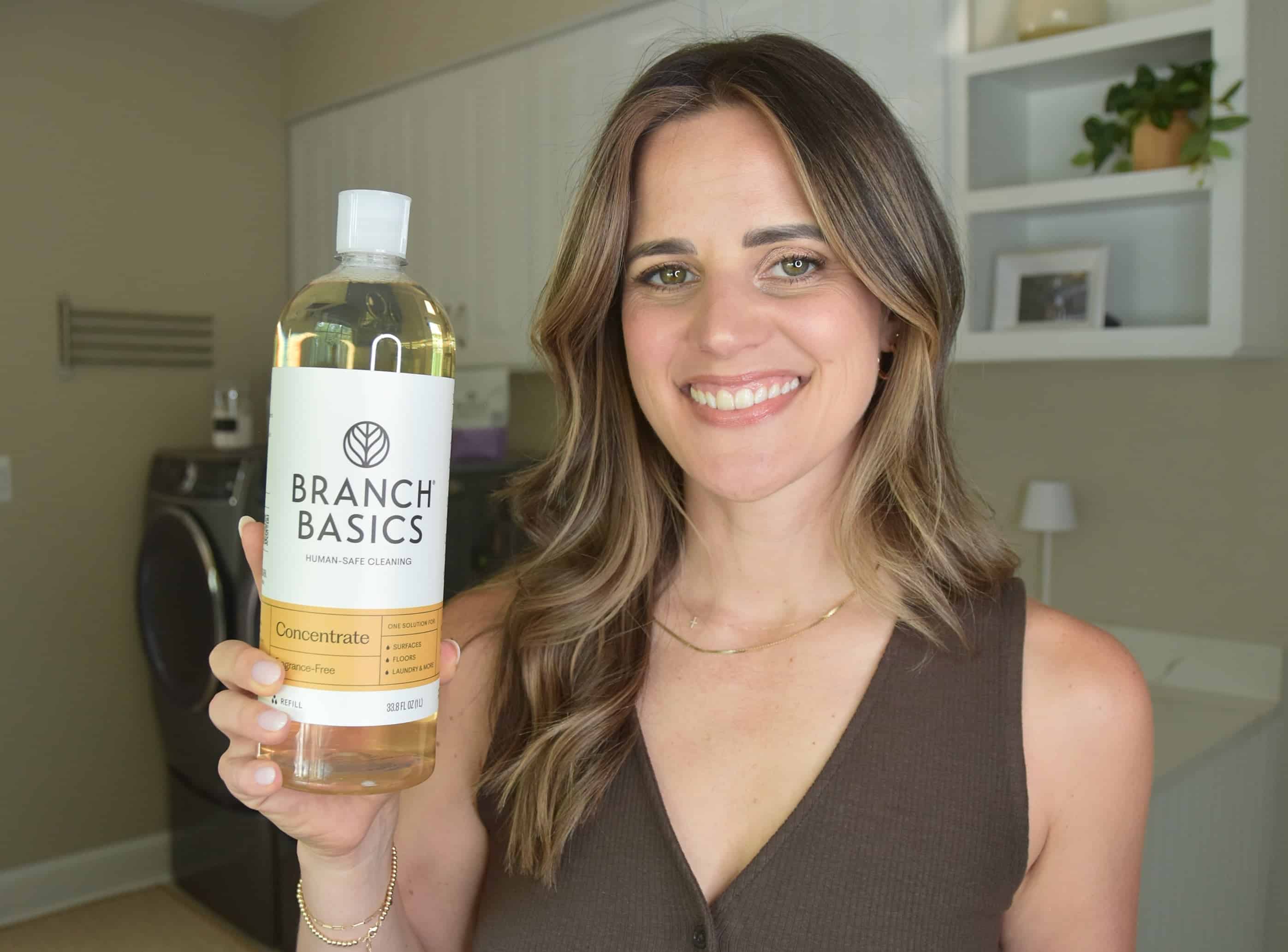 Noelle holding a bottle of the Branch Basics concentrate for testing and review.