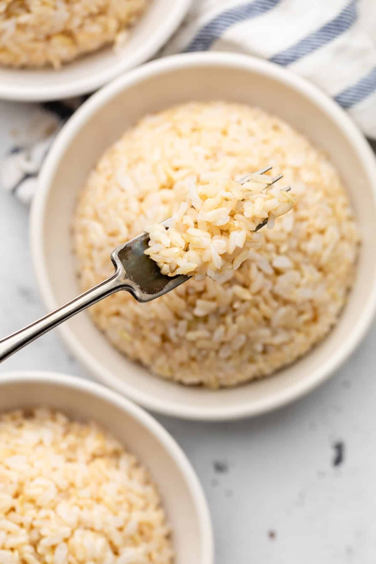 Brown rice in a bowl on a fork.