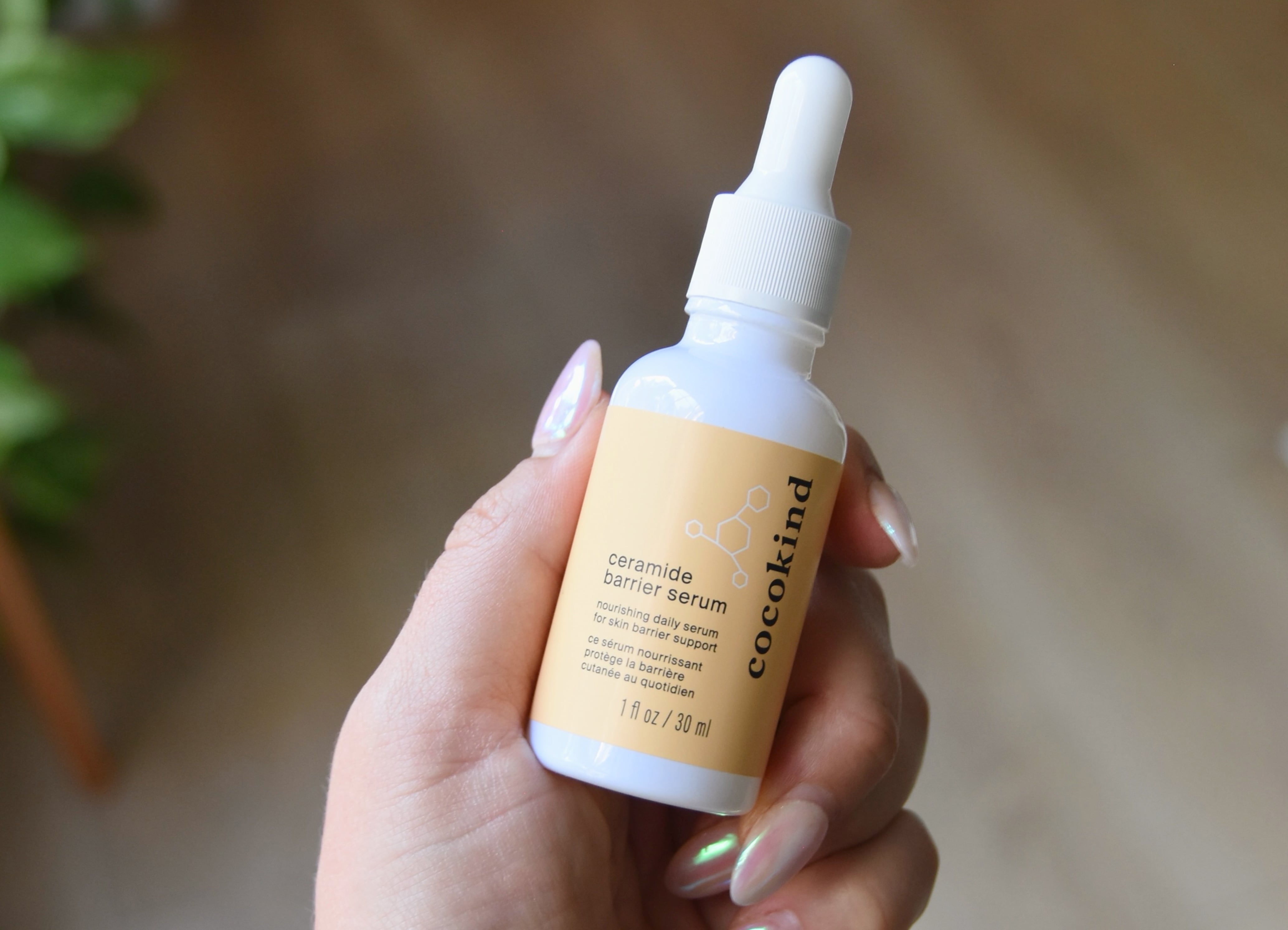 Holding a bottle of the Cocokind Ceramide Barrier Serum.