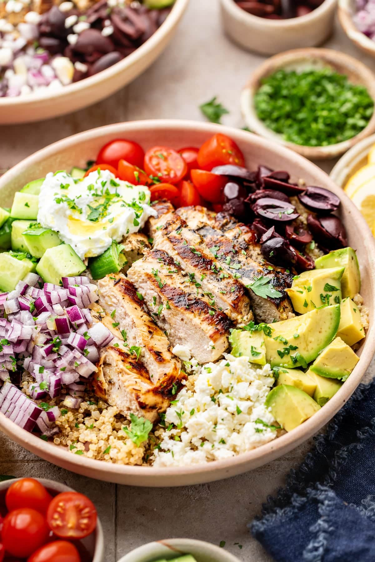 A quinoa chicken bowl fully assembled and topped with Greek yogurt and herbs.