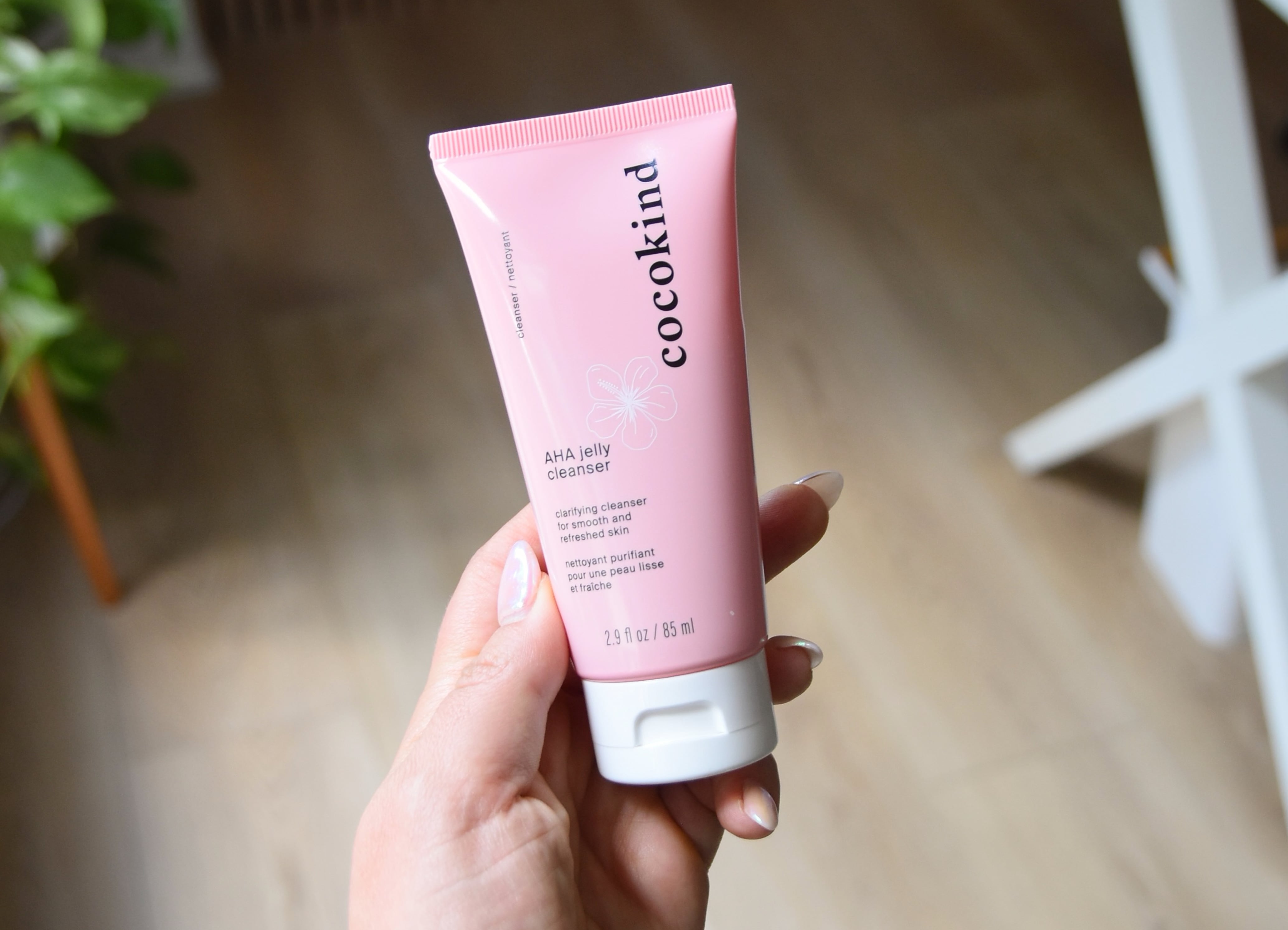 Holding a bottle of the AHA jelly cleanser.