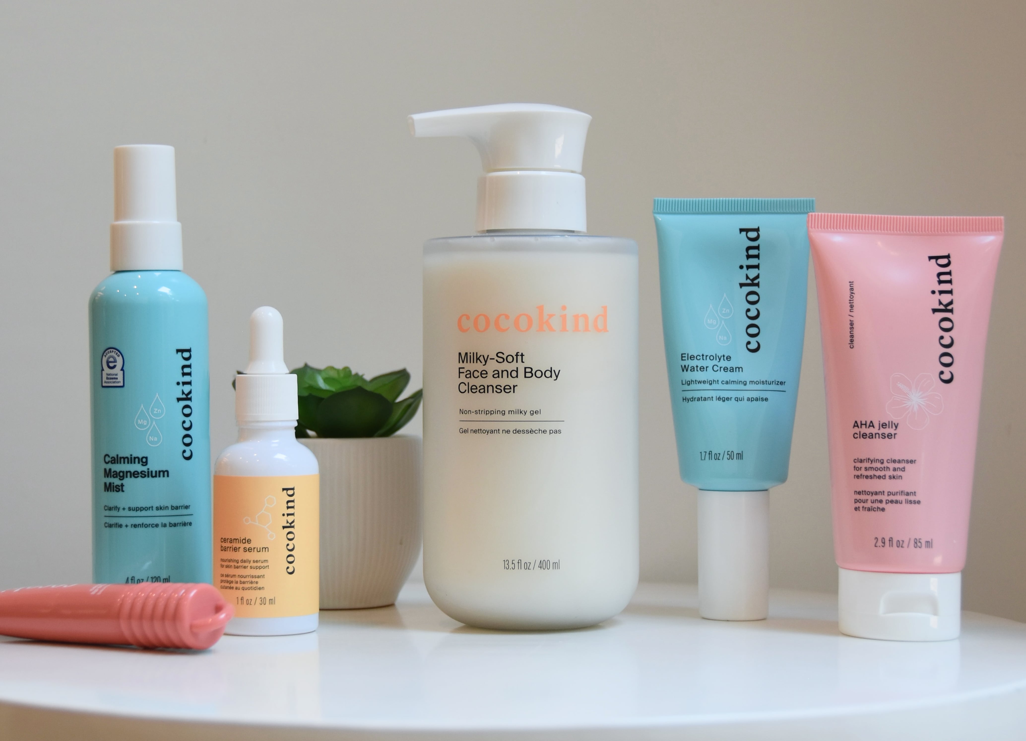 All of the cocokind products in the review on a small white table with a plant.