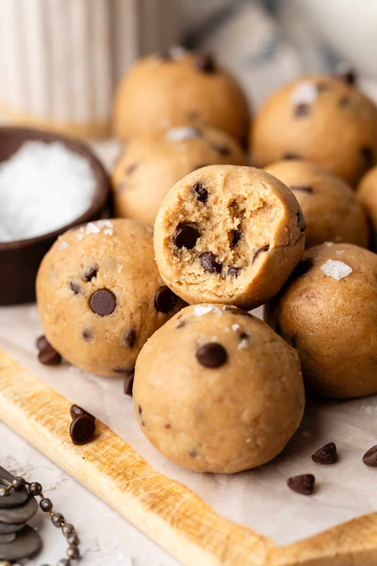 A close up of one cookie dough protein bite with a big bite taken out.