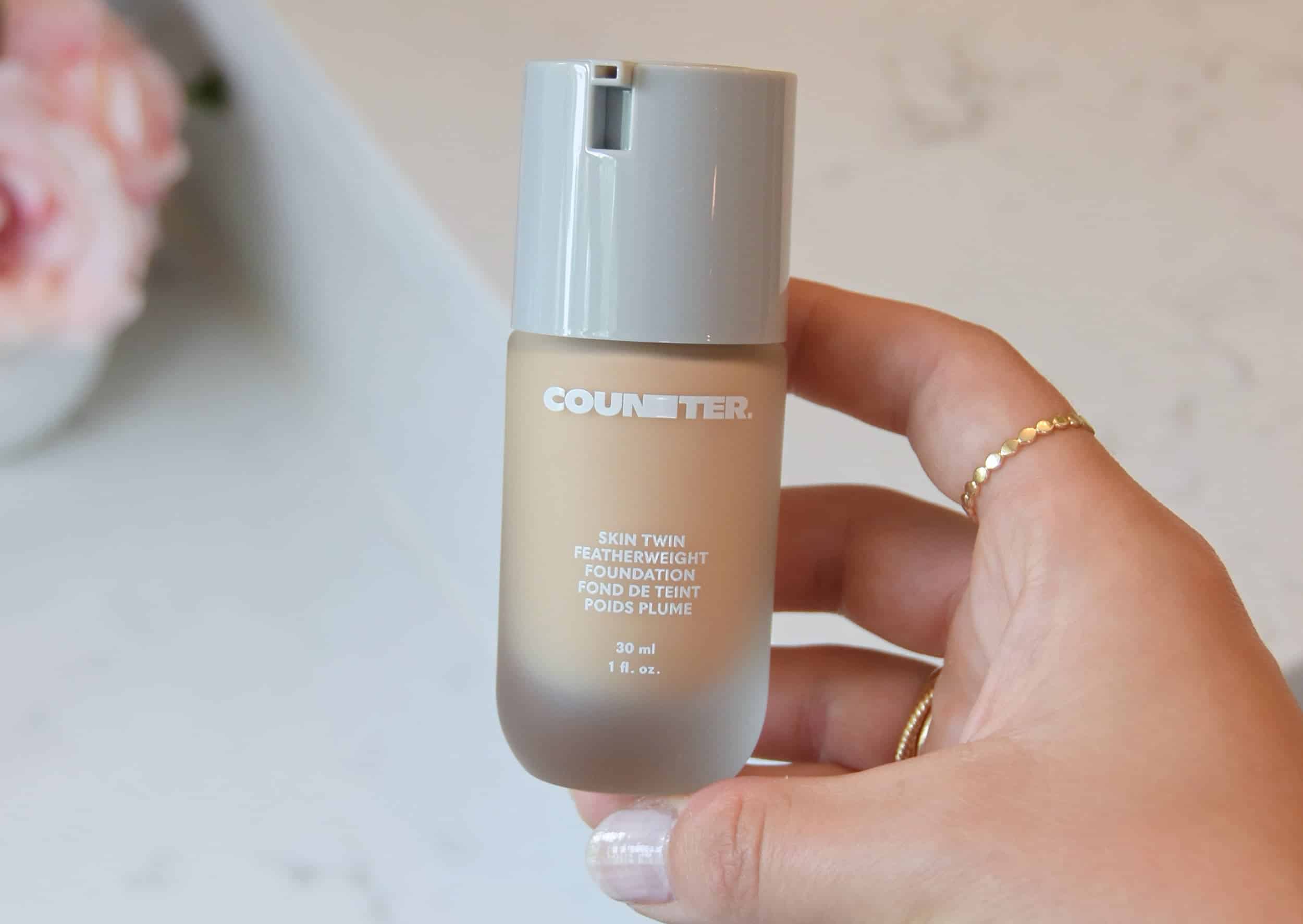 Holding the new Skin Twin Featherweight Foundation in the bathroom at a makeup stand.