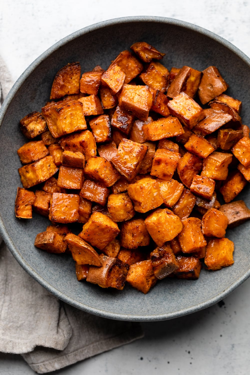 A bowl of sweet potatoes right out of the oven ready to serve.