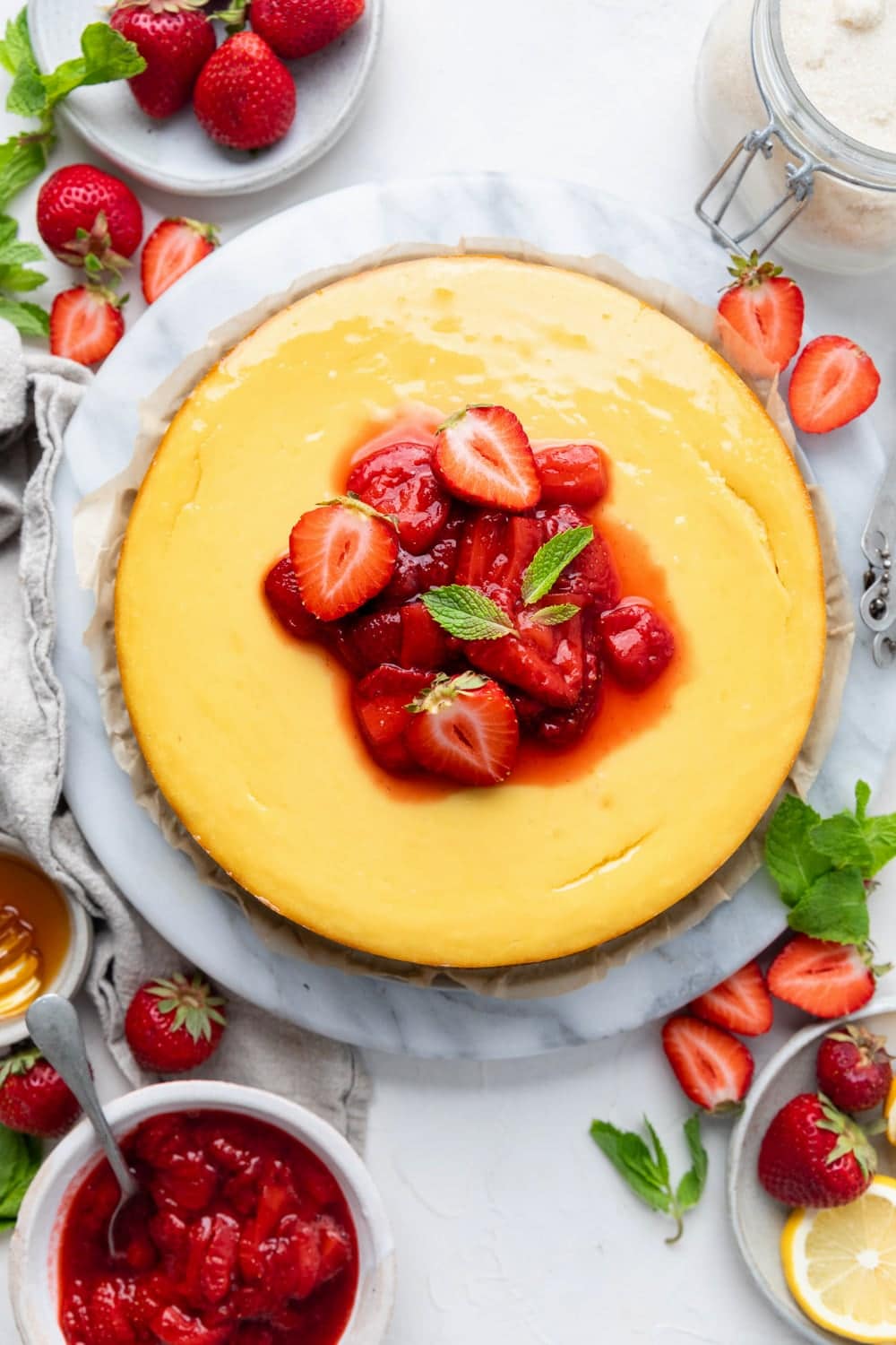 A whole dairy free cheesecake made with dairy free cream cheese decorated with strawberries.