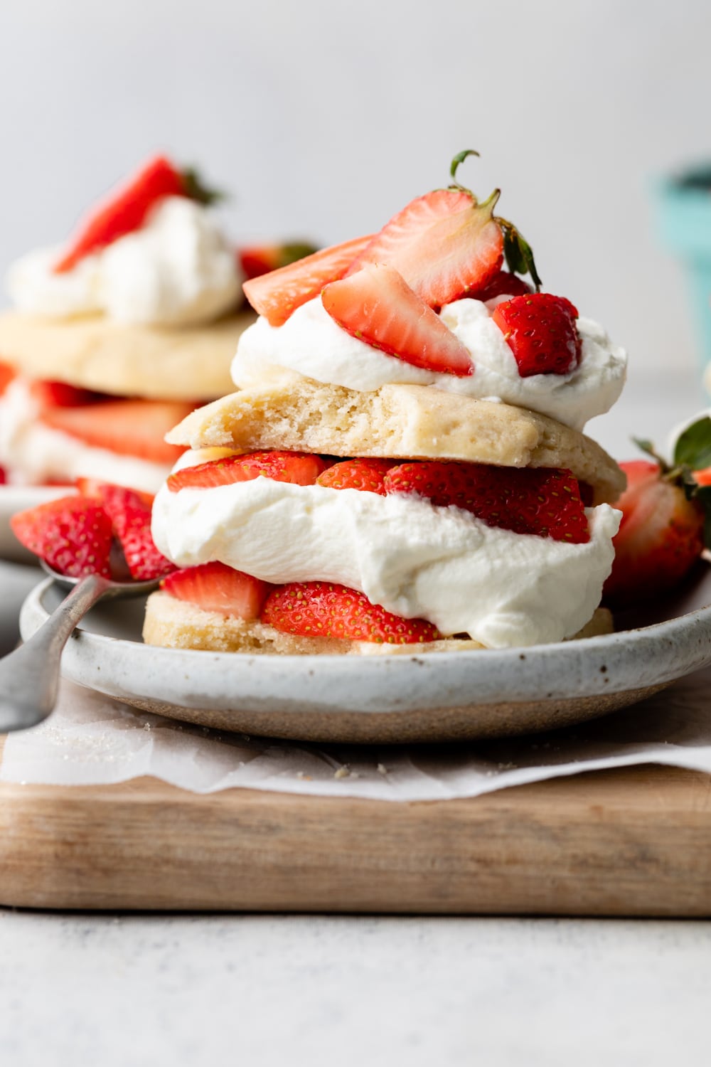 Gluten free strawberry shortcake assembled with whipped cream and strawberries on top.