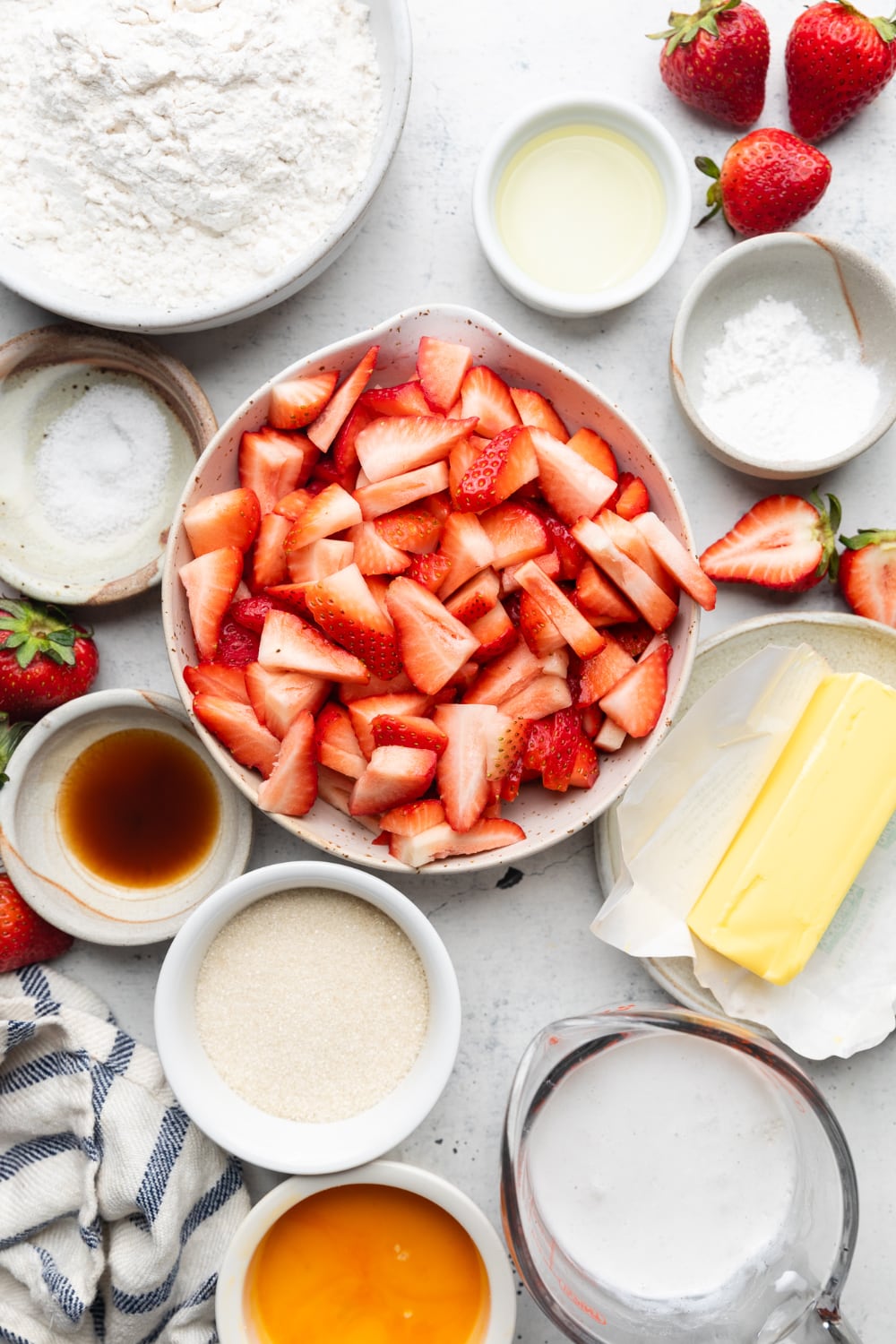 Bowl of ingredients including strawberries, butter, sugar, and milk.