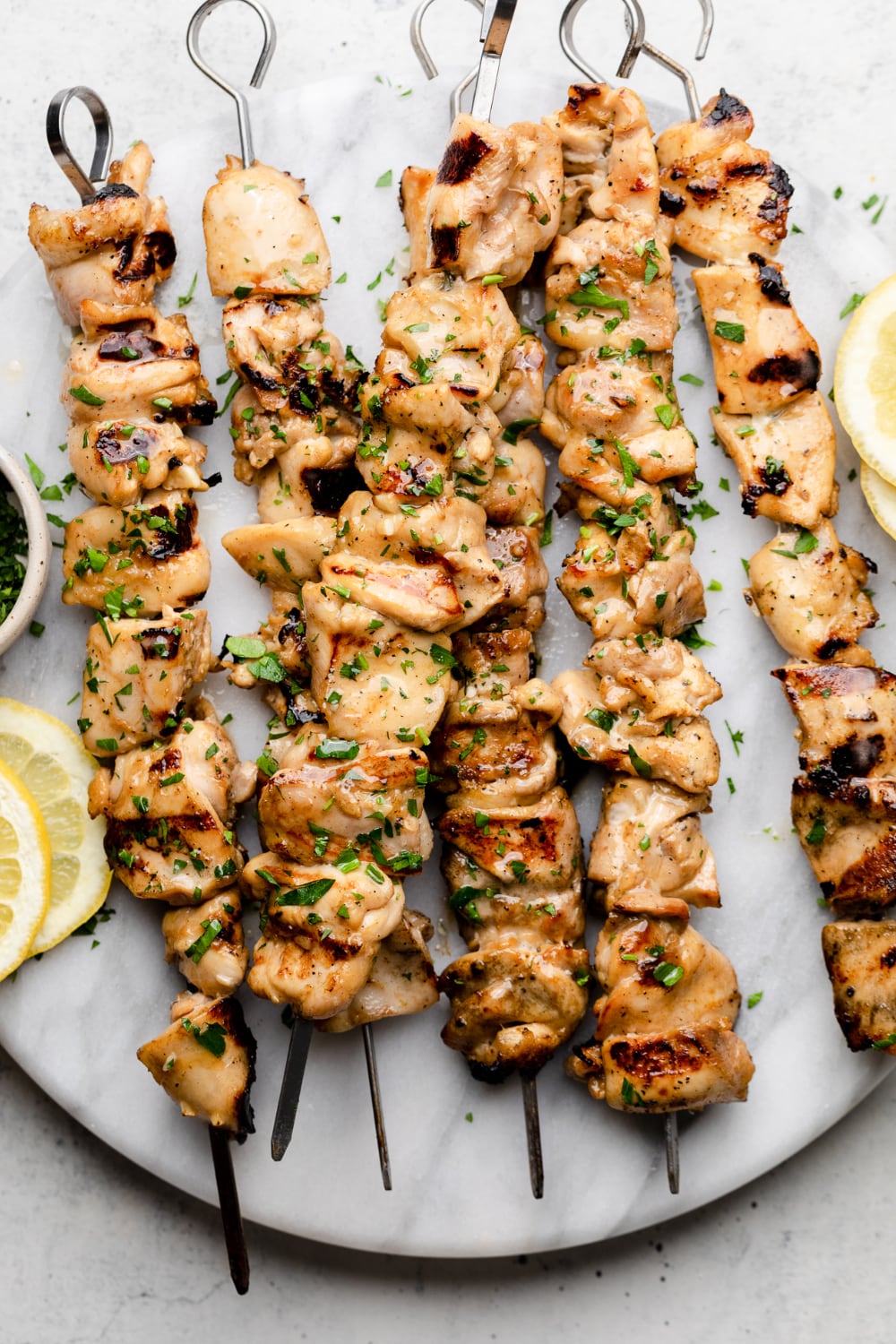 Skewers with marinated chicken and sprinkled with fresh herbs.