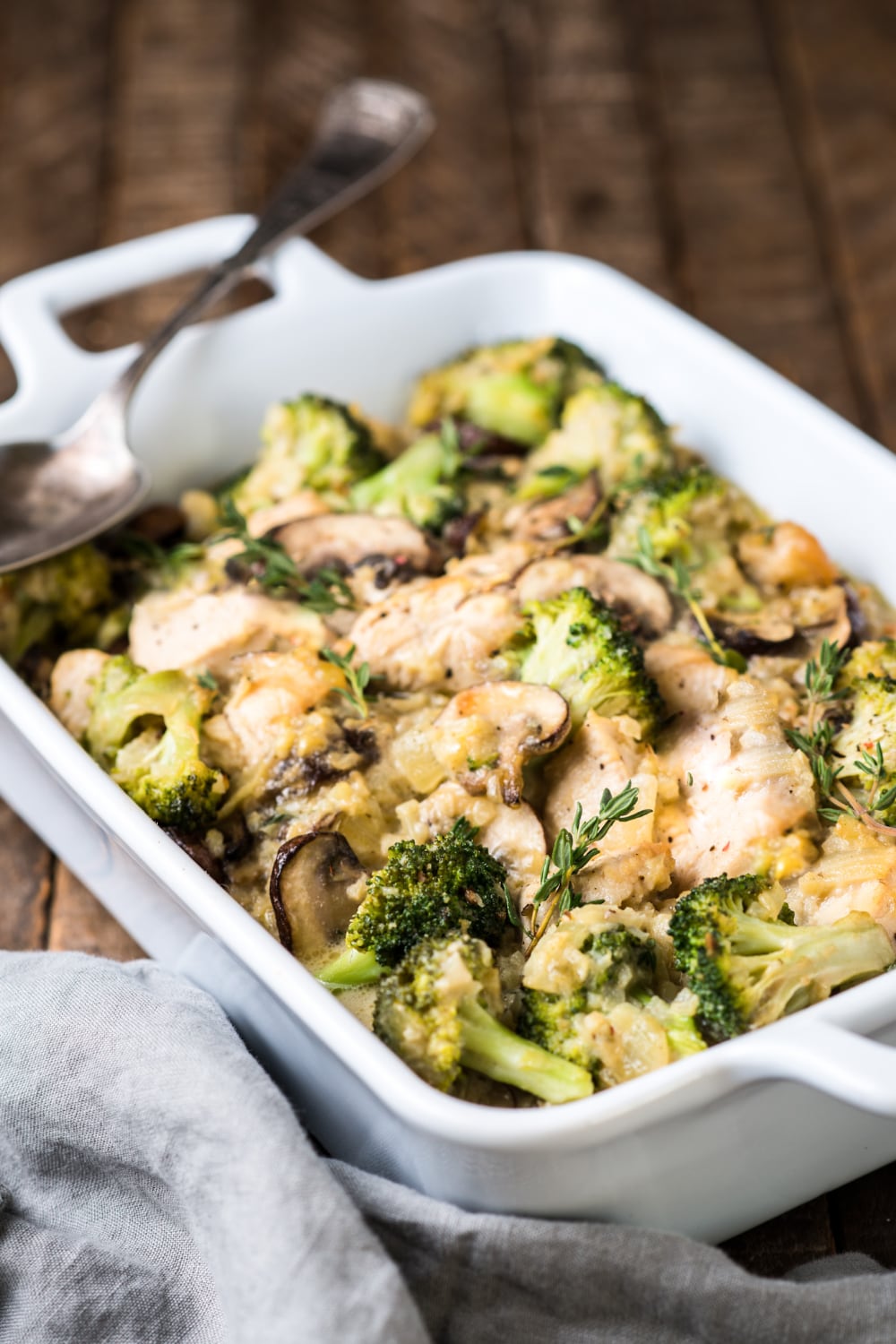 a closer shot of chicken and broccoli in a casserole dish with rosemary on top