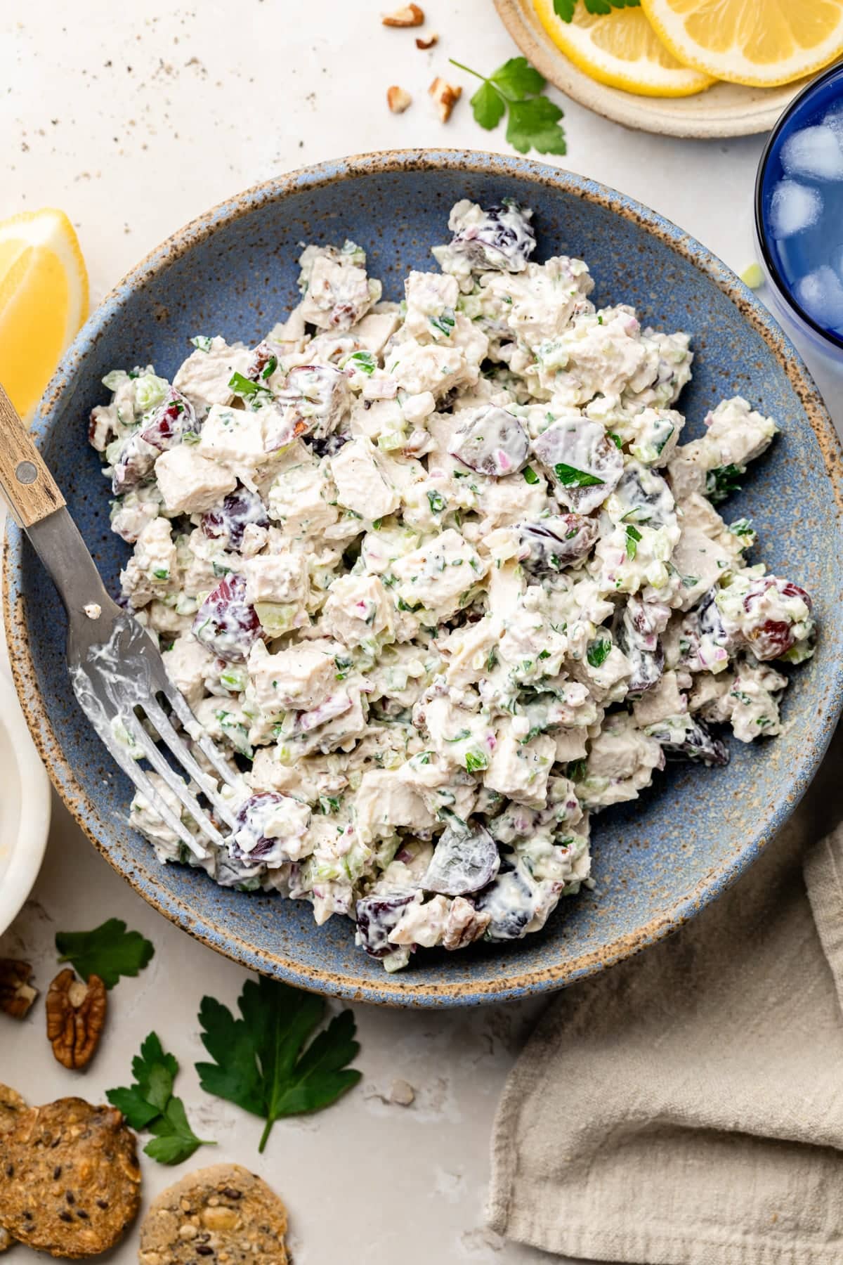A large serving of high protein chicken salad on a plate with a fork with crackers by it.