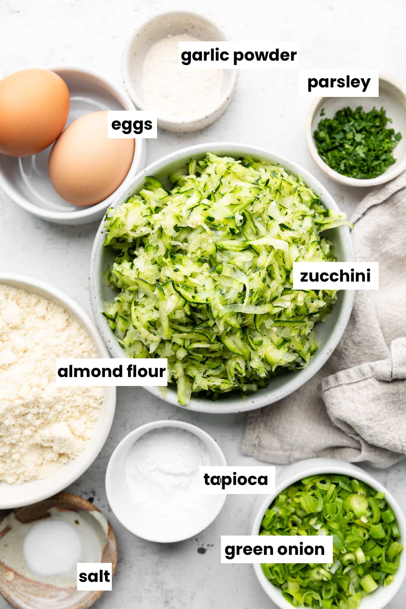 Ingredients for the recipe, including shredded zucchini in a bowl.