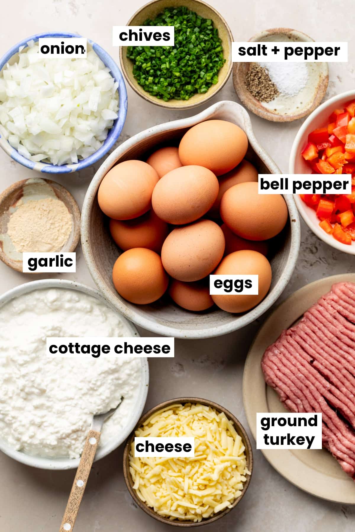 Ingredients in the recipe, including eggs, ground turkey, bell pepper, onions, cottage cheese, shredded cheese, garlic, chives, salt, and pepper.