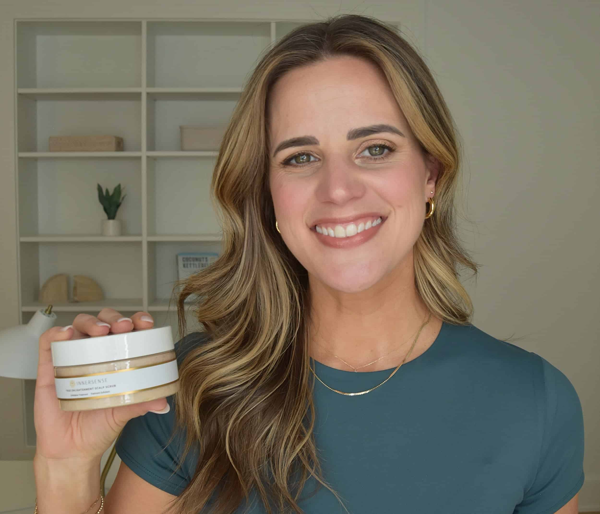Noelle holding a jar of the innersense scalp scrub for review.