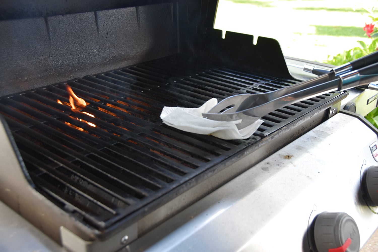 Oiling the grill grates with a well-oiled paper towel.