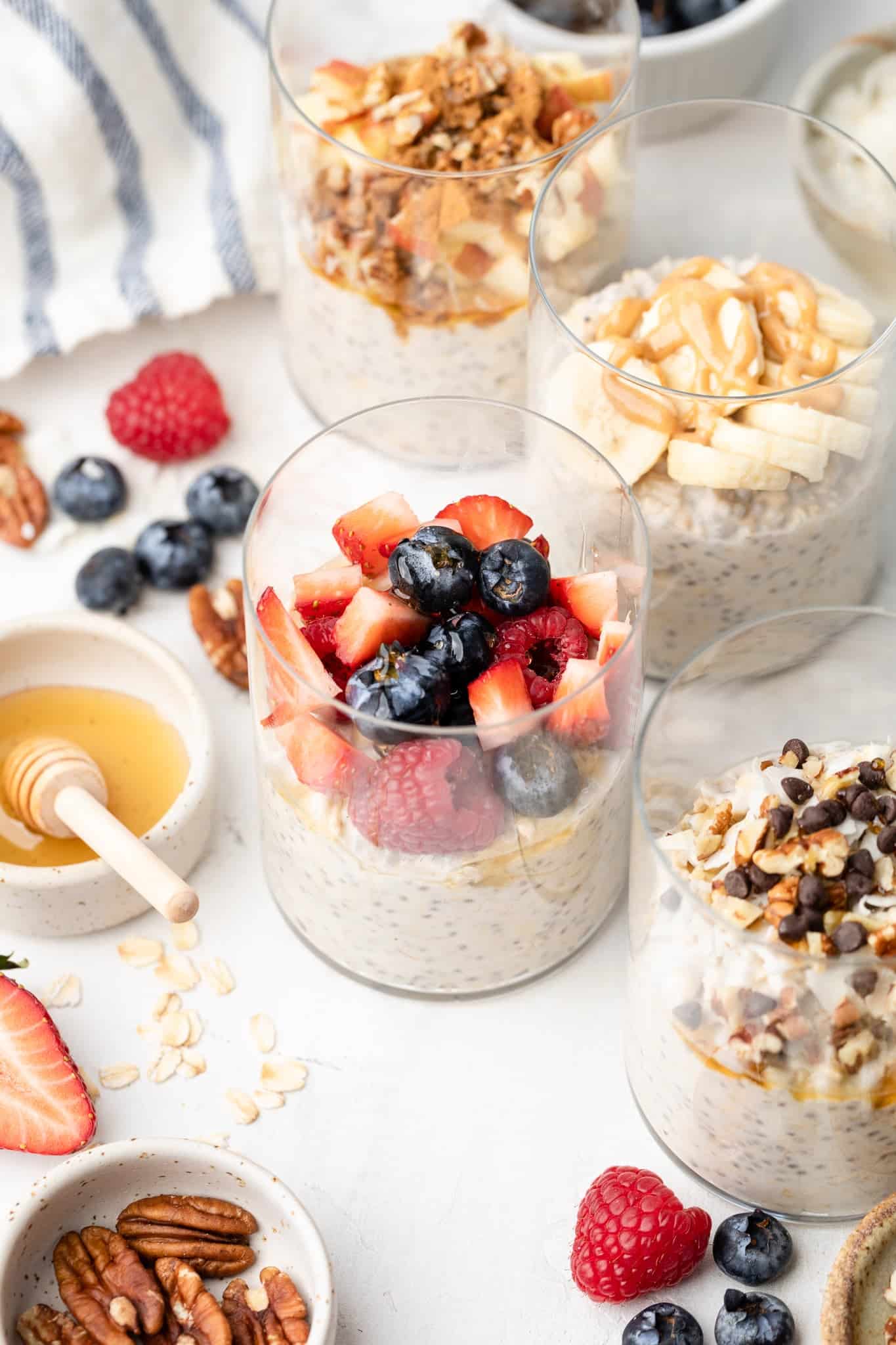 Overnight oats made with coconut milk in 4 different glass jars with different toppings.