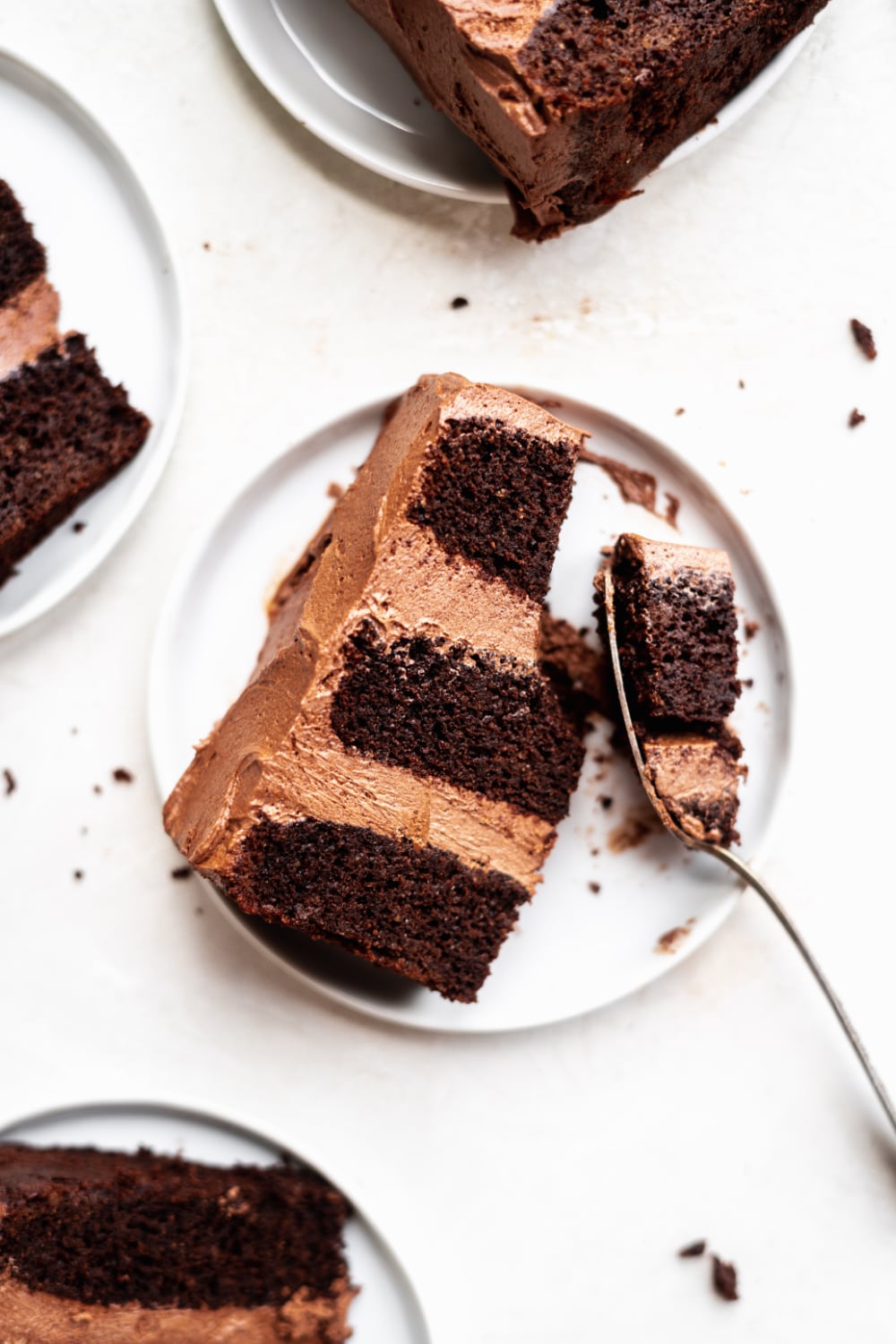 A slice of paleo chocolate cake with a fork taking a bite out. 