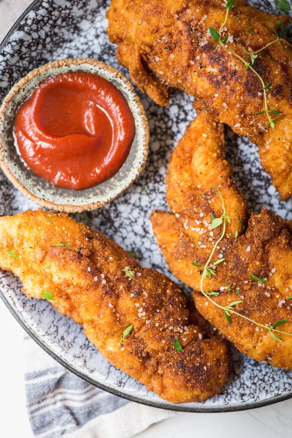 up close shot of paleo chicken tenders and primal kitchen ketchup for dipping
