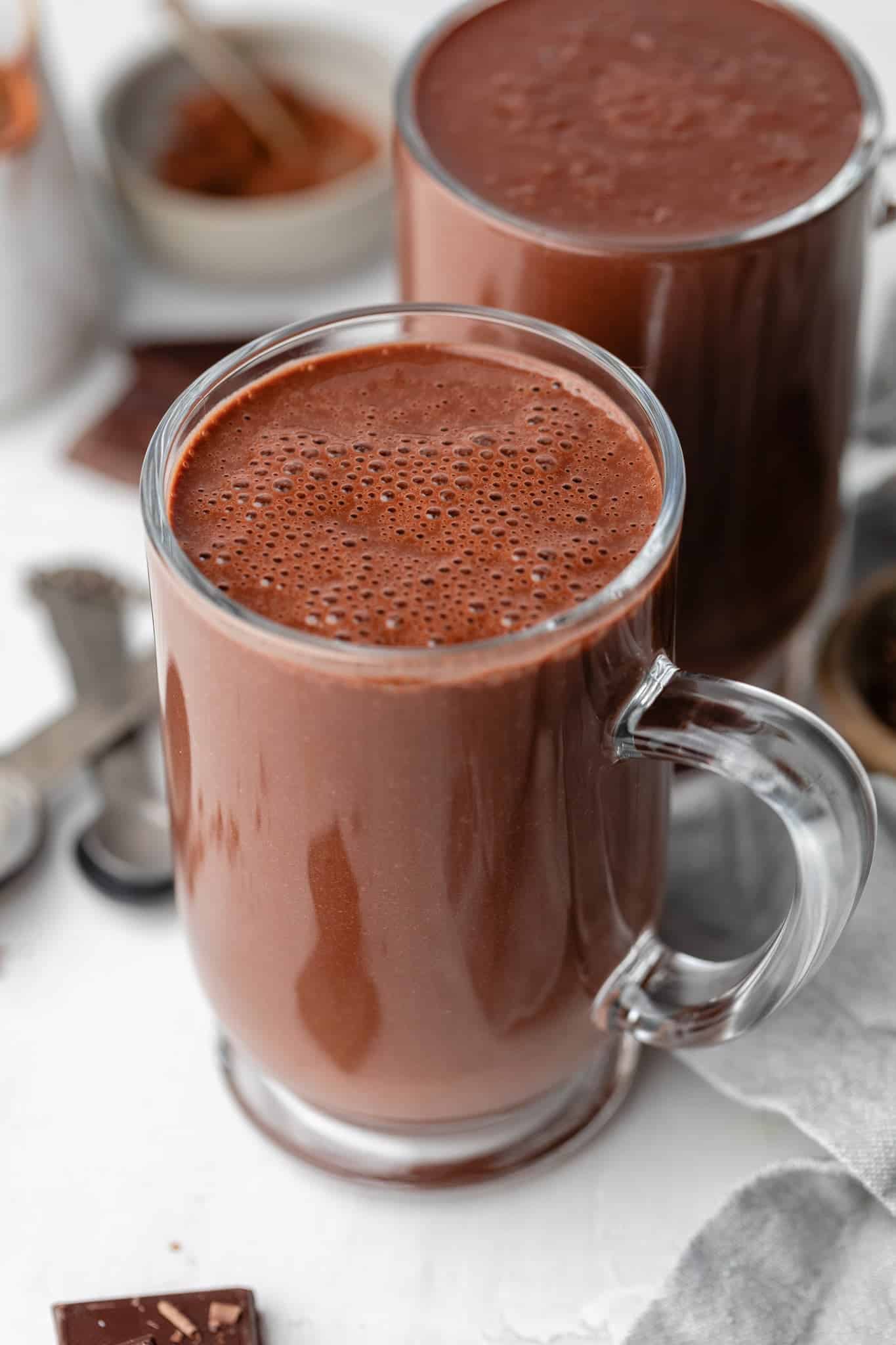 A clear mug with warm hot chocolate and no toppings.