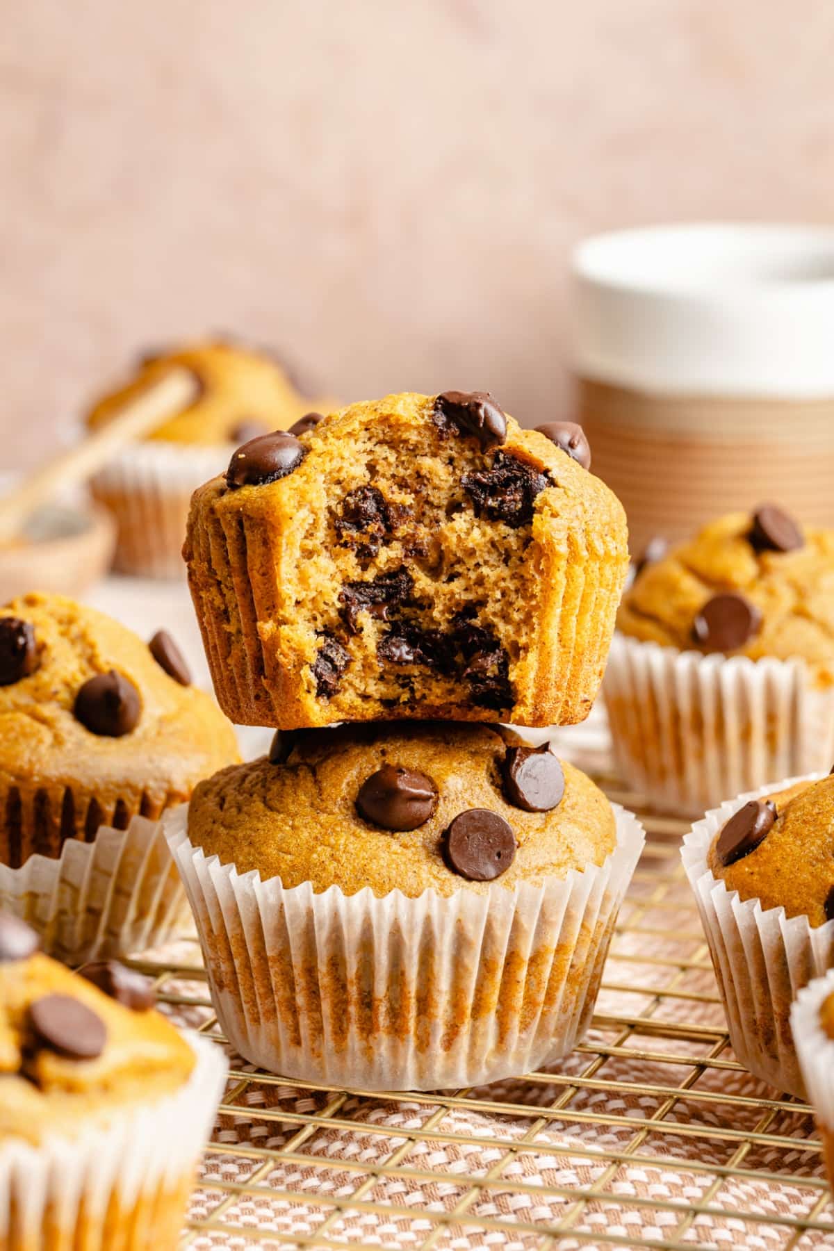 Two muffins stacked on top of each other, with the top one having a bite taken out of it.