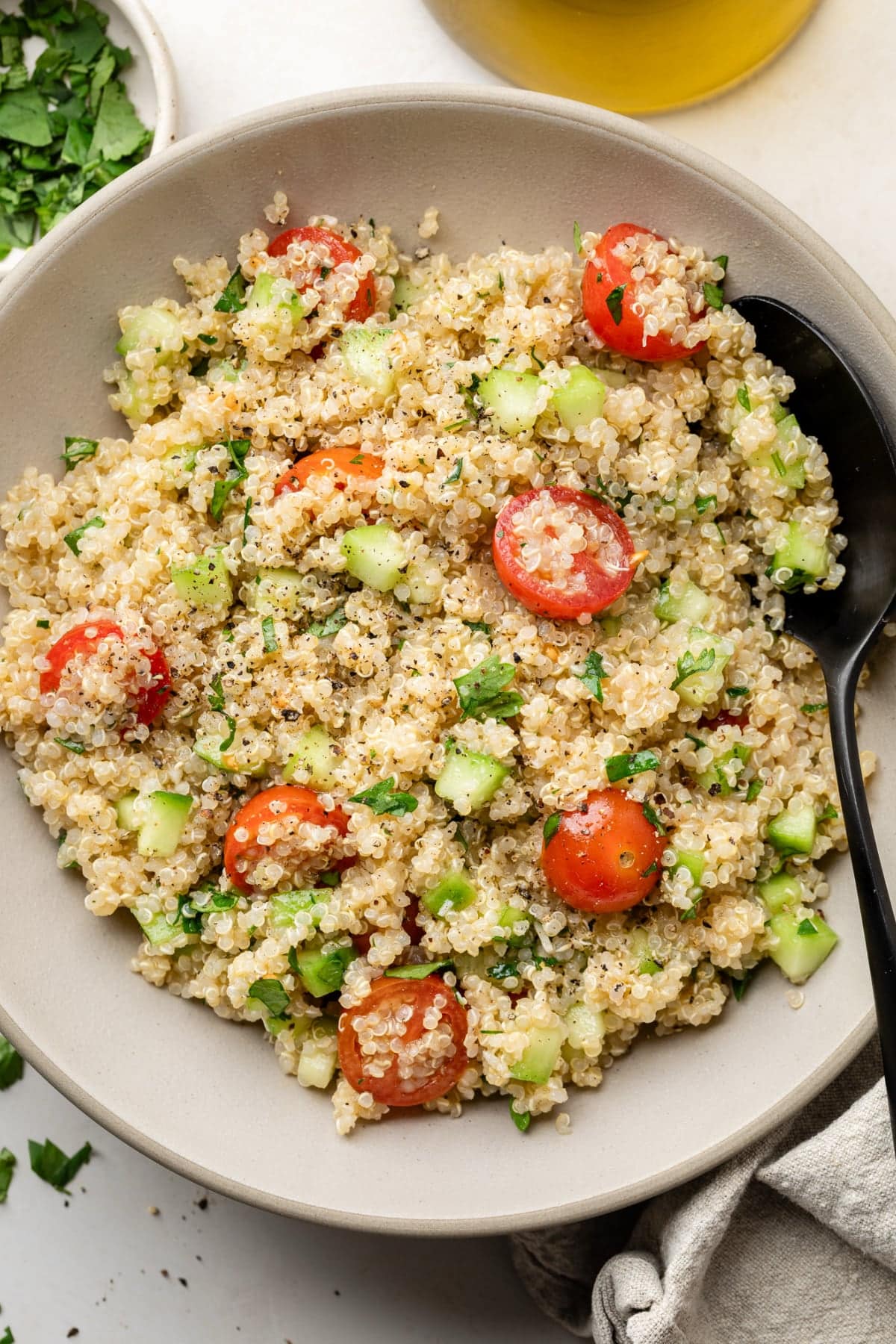 A large spoon and a big bowl of the salad ready to be served at a dinner party.