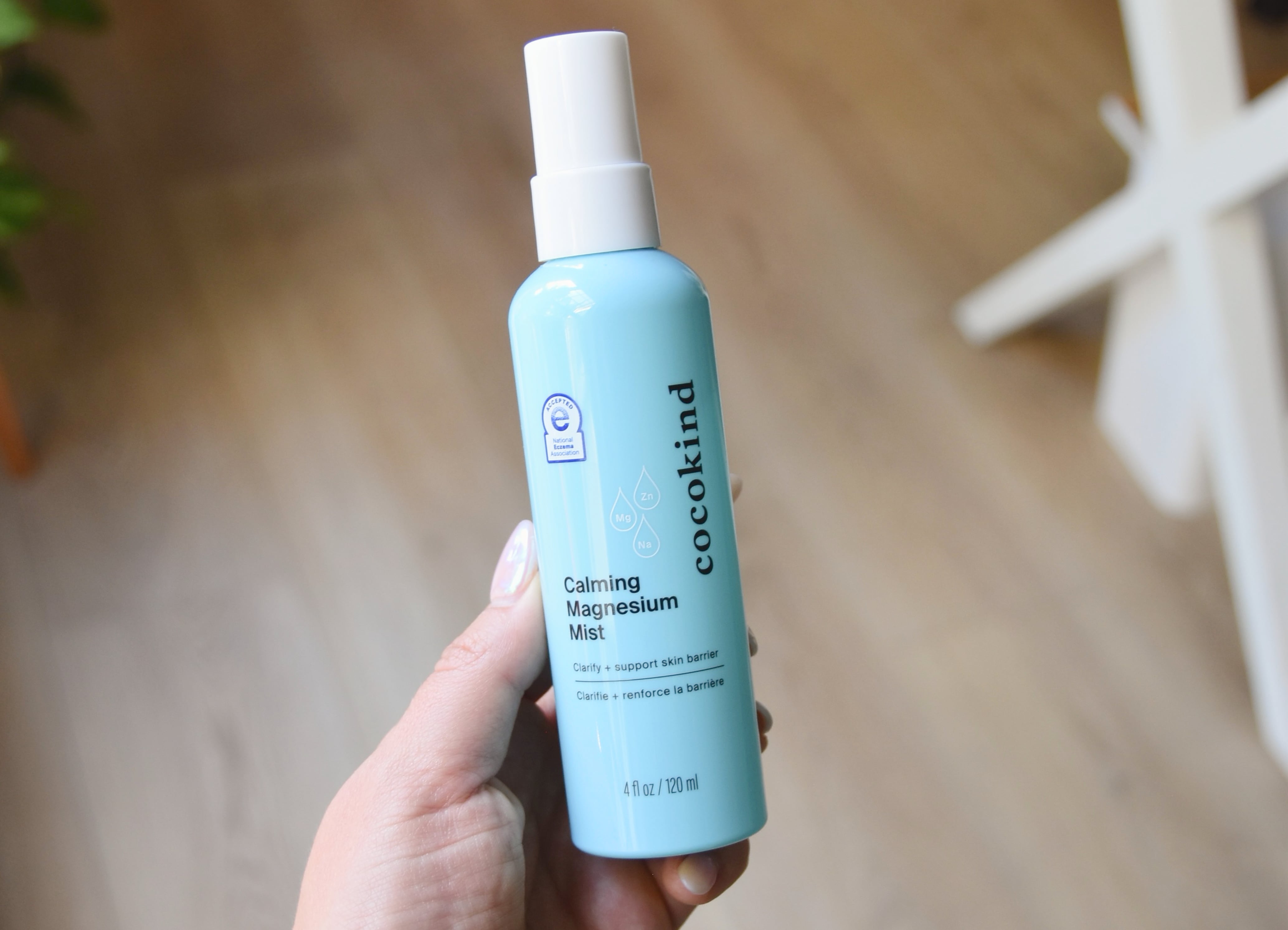 Holding a bottle of the Calming Magnesium Mist.