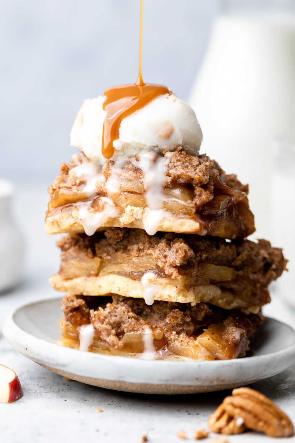 three apple pie bars stacked on top of each other with ice cream and caramel. 
