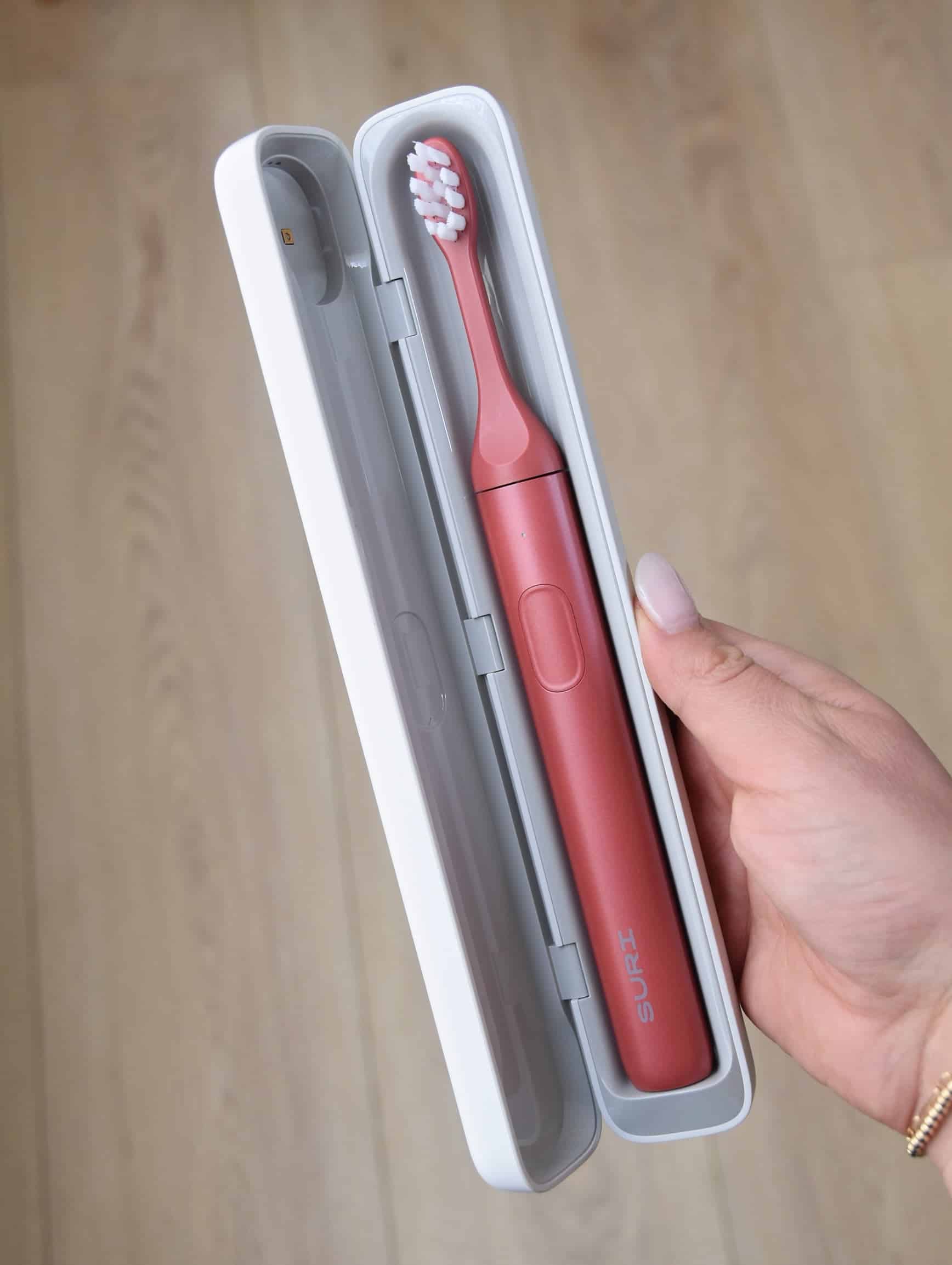 Holding the SURI 2.0 toothbrush in the new updated case.
