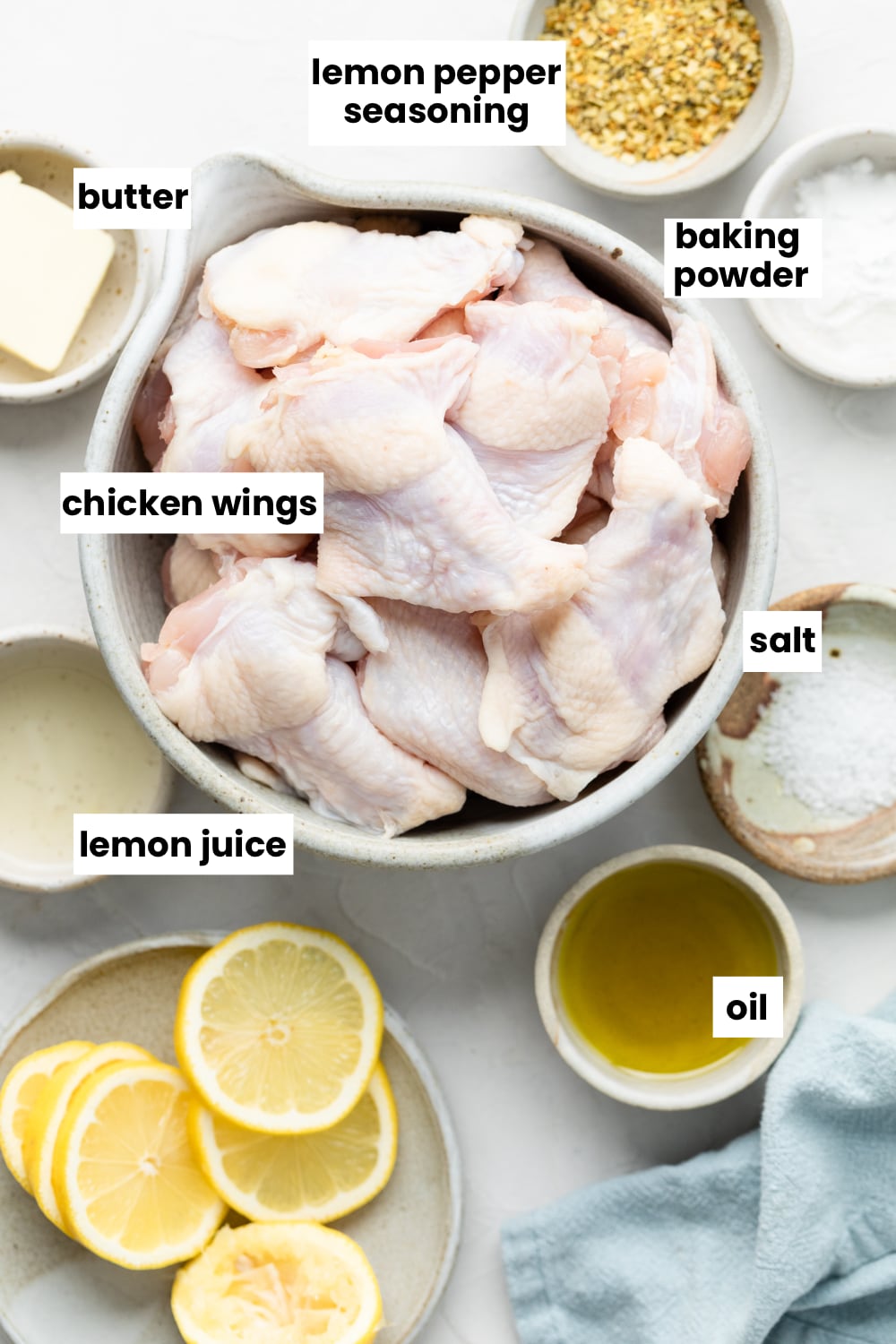 Ingredients for the recipe, including chicken wings, lemon pepper seasoning, oil, butter, salt, baking powder, and lemon juice. 