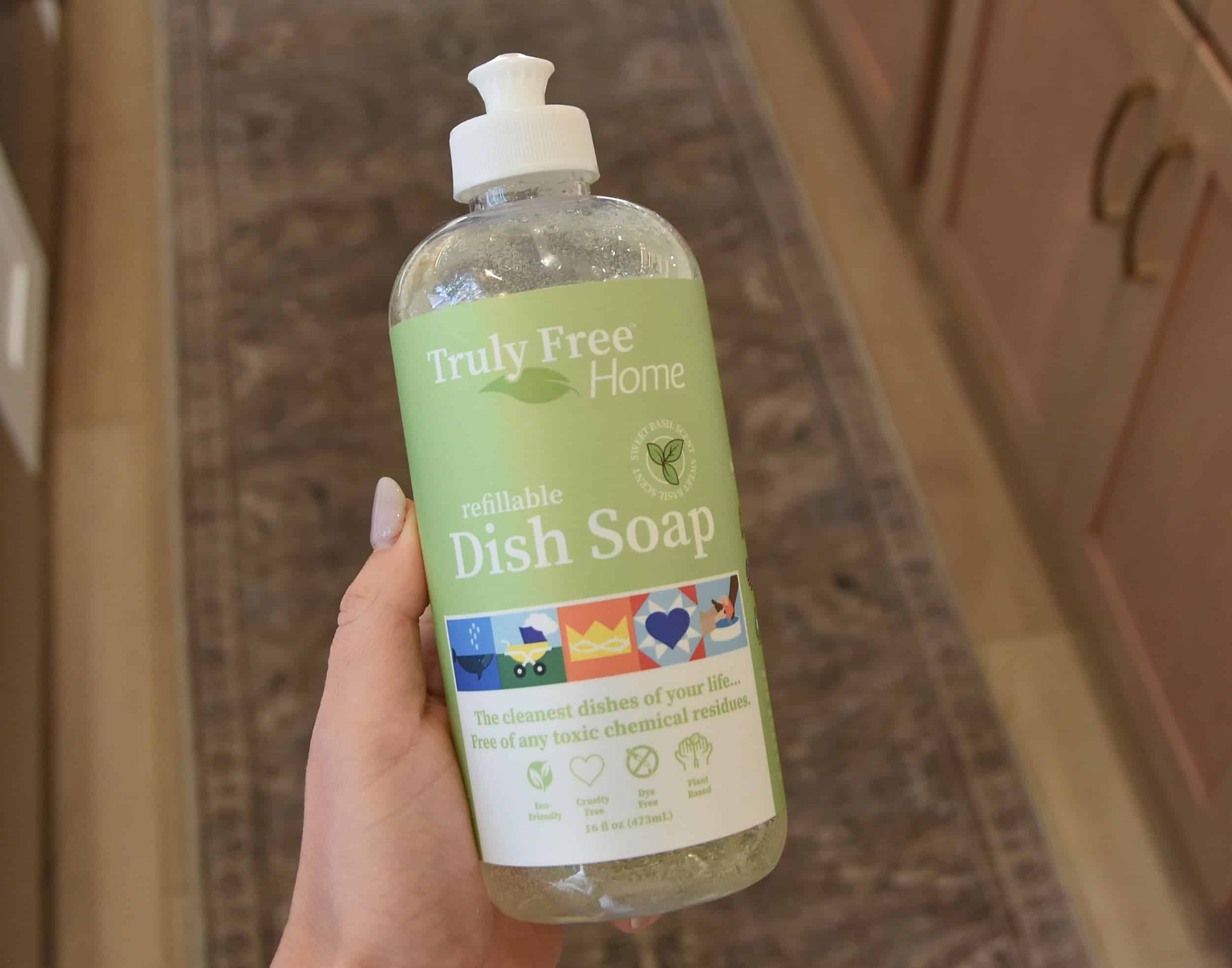 Holding a bottle of the Truly Free Dish Soap in my hand with the concentrate added and water added.