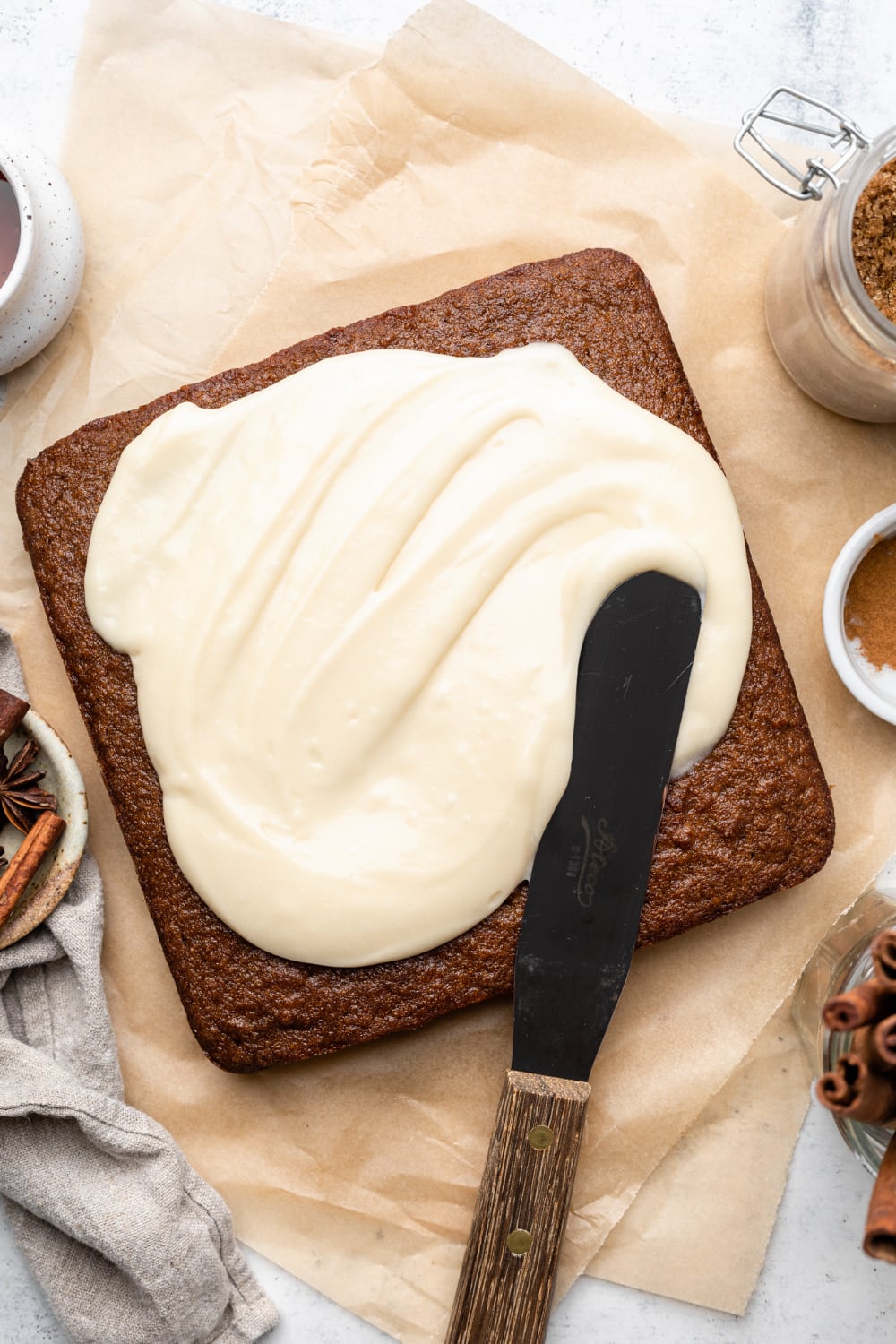 dairy free cream cheese frosting being spread on pumpkin bars