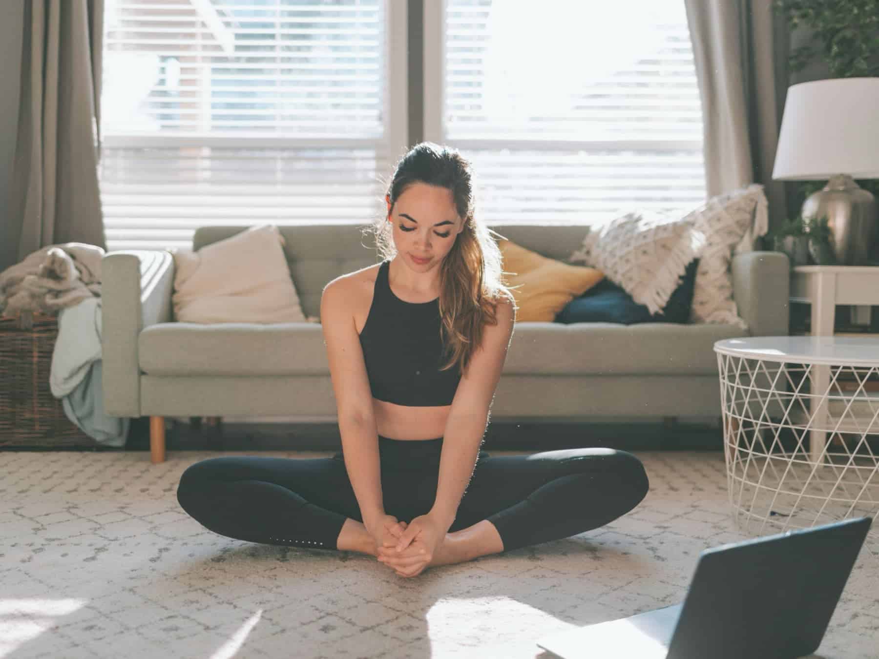 A woman working out in her home to improve her stress and cortisol.